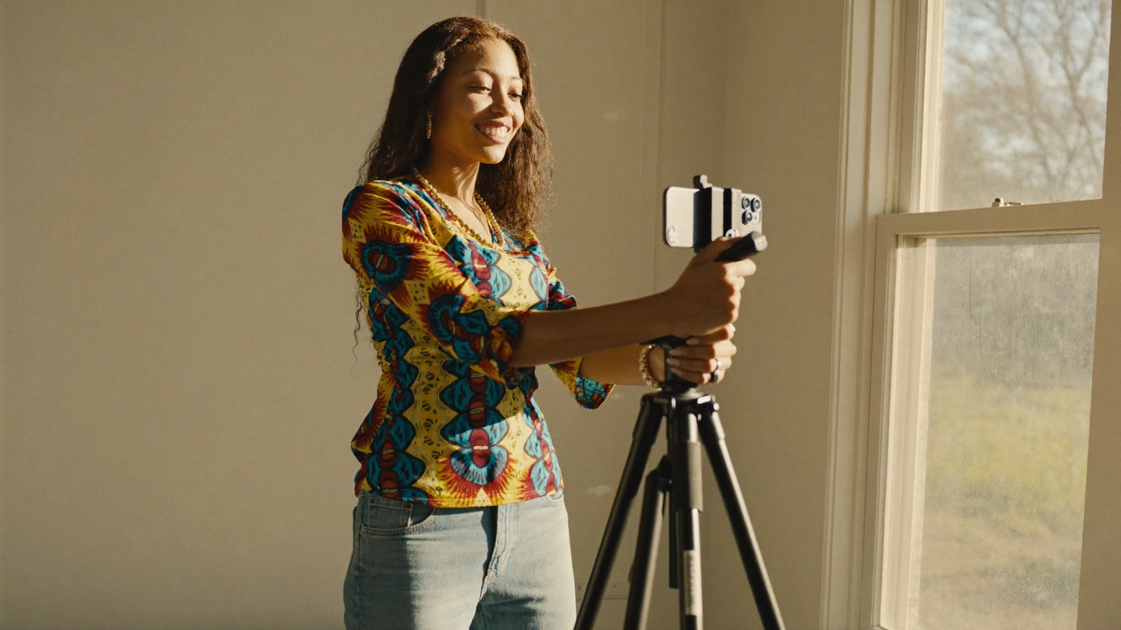 Creator setting up her own phone on a tripod in her own room in morning light
