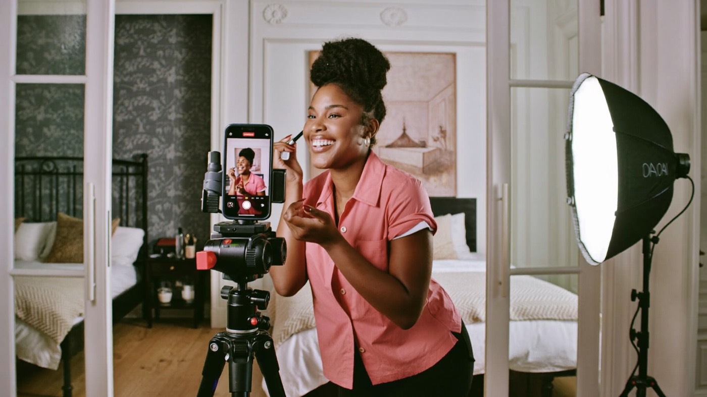 Creator filming with a phone tripod in daylight